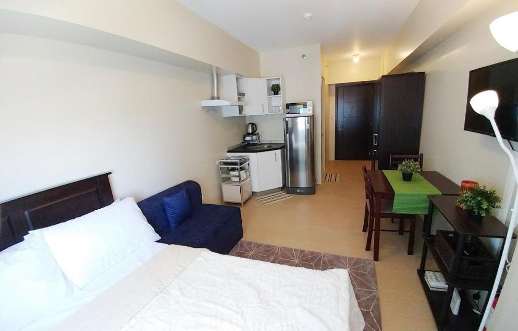 a room with a bed and a kitchen with a table at Avida Towers Davao, in City Center, Wifi, Huge Pool in Davao City