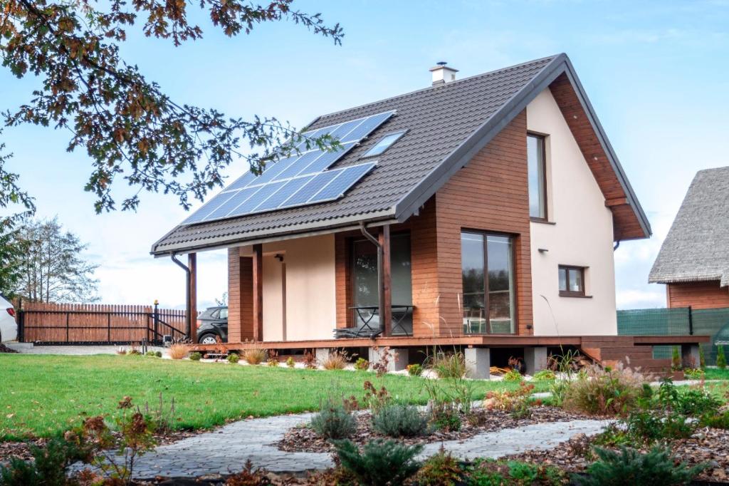 une maison avec des panneaux solaires sur le toit dans l'établissement Relax Houses - Domy Mazur, à Małkinie