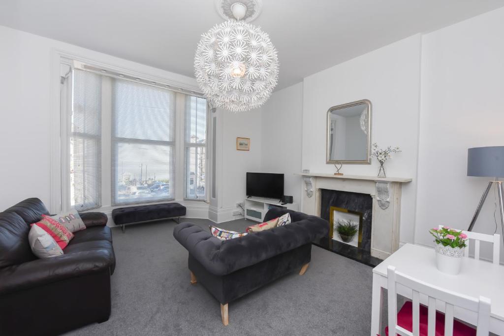 a living room with couches and a chandelier at Fantastic Sea View, 1 bed sleeps 2 in Broadstairs