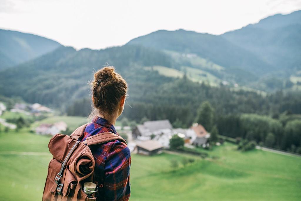 Lassing的住宿－Ferienwohnungen Orth，一位带着背包的女人,看着群山