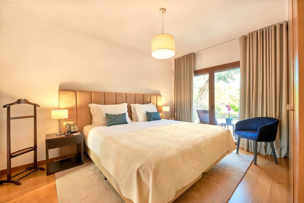 a bedroom with a large bed and a blue chair at Cascade Wellness Resort in Lagos