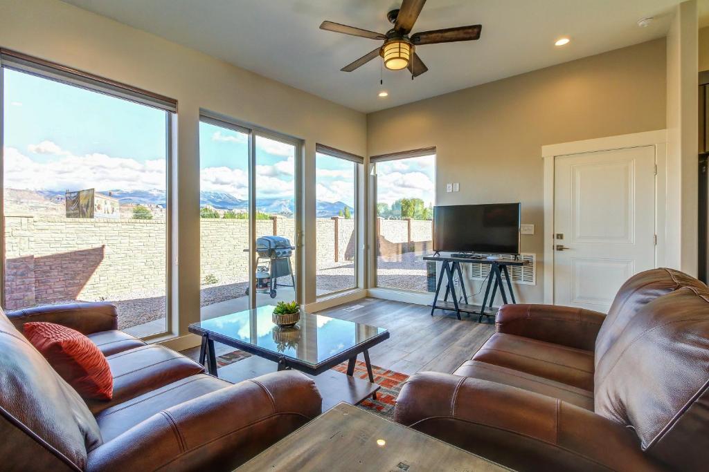 a living room with leather couches and a tv at Rim View 2 in Moab