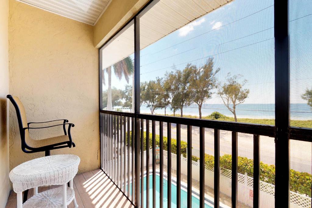 een balkon met een bank en uitzicht op de oceaan bij Sunset Villa 2 in Bradenton Beach