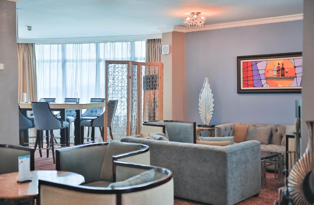 a living room with a couch and chairs and a table at Swiss Inn Nexus Hotel in Addis Ababa