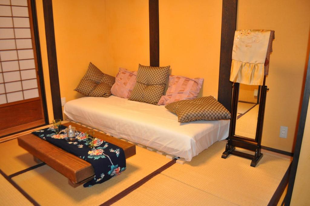 a room with a bed and a table and a chair at Sakara Gion in Kyoto