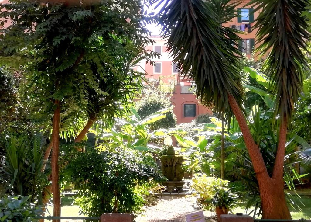 um jardim com palmeiras e um edifício ao fundo em A casa di Edi em Roma