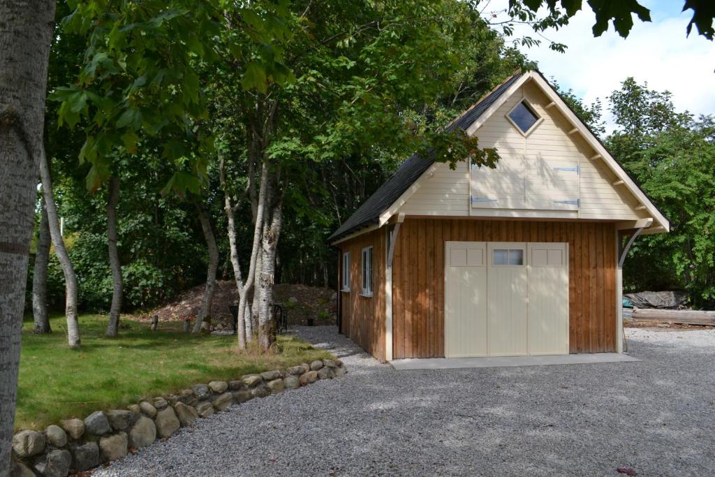 a garage with a large white garage door at Loch Ness Studio Blairbeg in Drumnadrochit