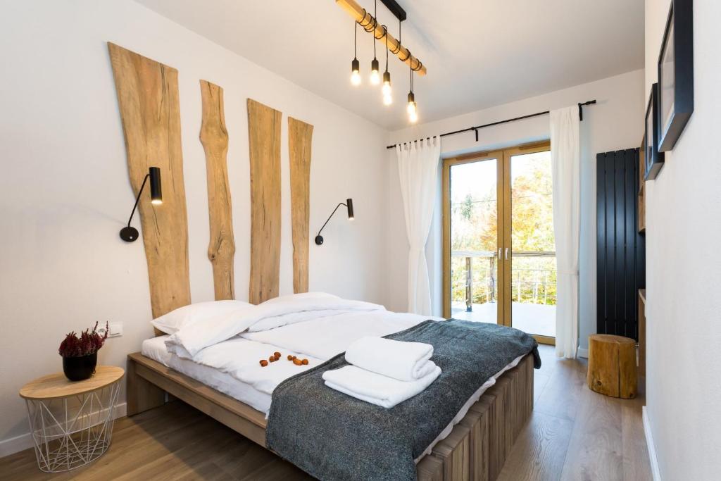 a bedroom with a large bed with a wooden headboard at Apartamenty Willa Marko z sauną, grillowiskiem i rowerownią - Dream Apart in Szczyrk