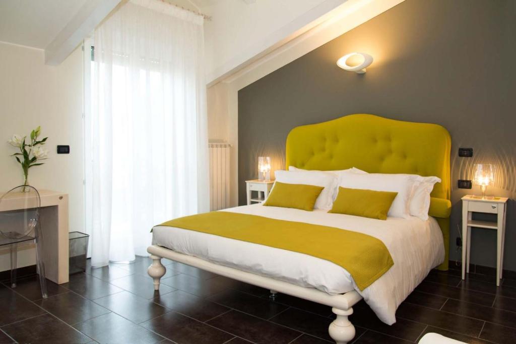 a bedroom with a large bed with a yellow headboard at Pepe's Home B&B in Nichelino