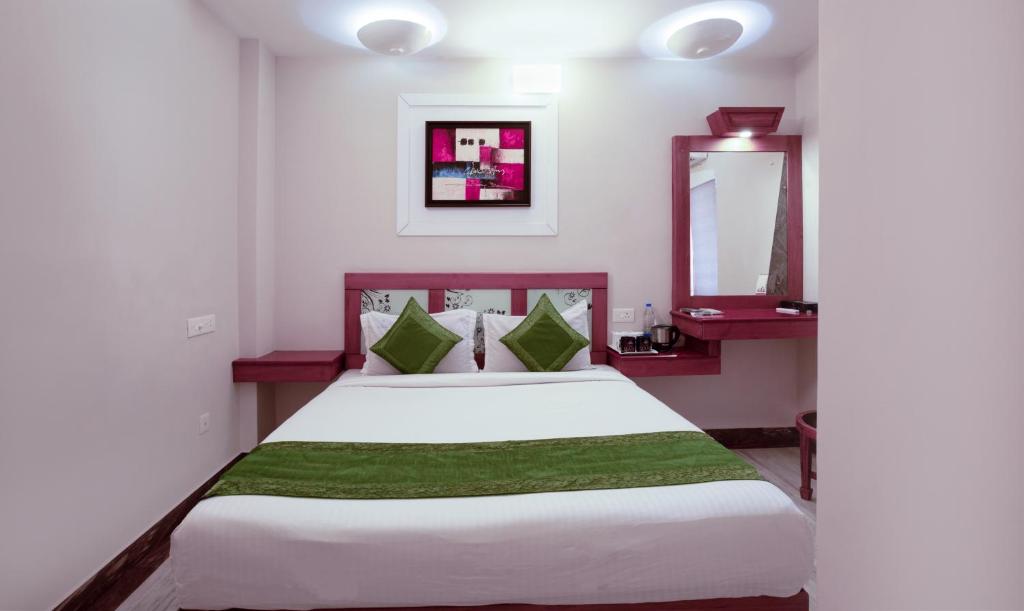 a bedroom with a large white bed and a mirror at Treebo The Qasr in Cochin