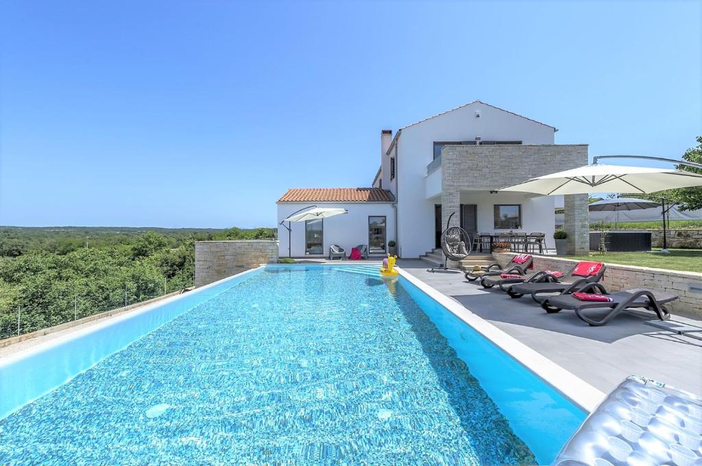 a villa with a swimming pool and a house at Villa Meli in Sveti Lovreč Pazenatički