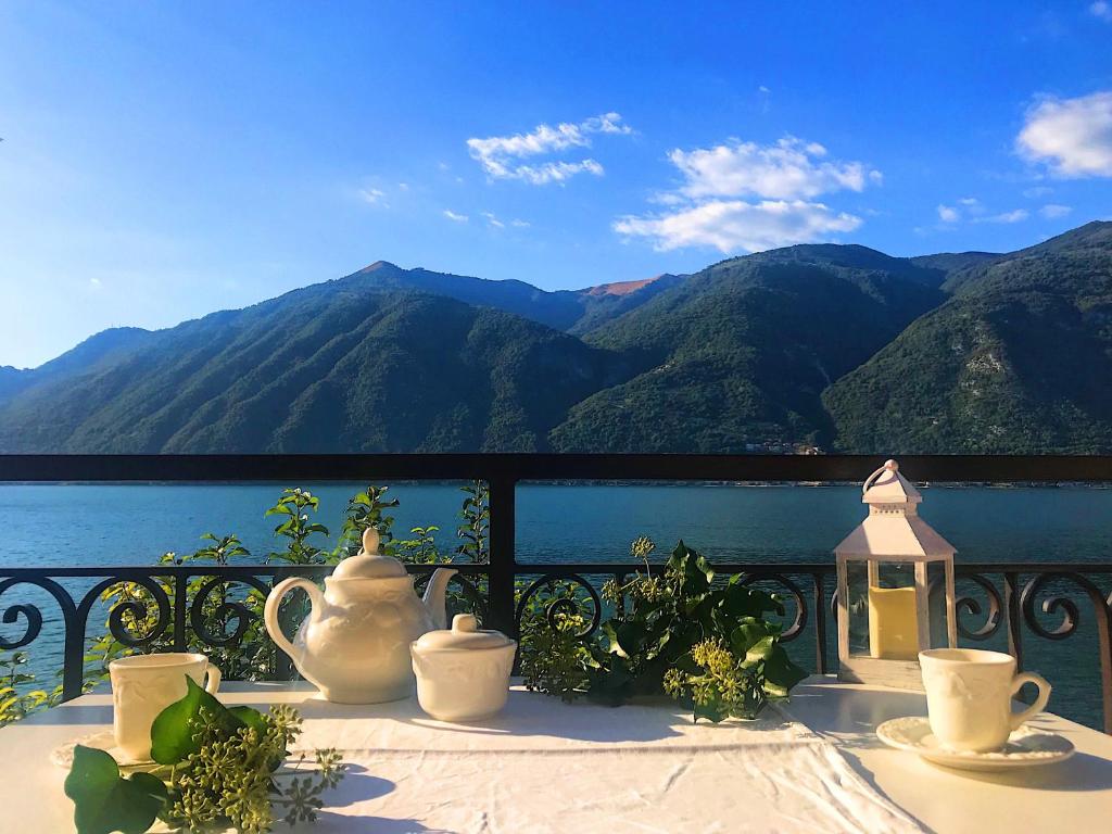 een tafel met vazen en uitzicht op de bergen bij Holidays Home Rivabella in Lezzeno