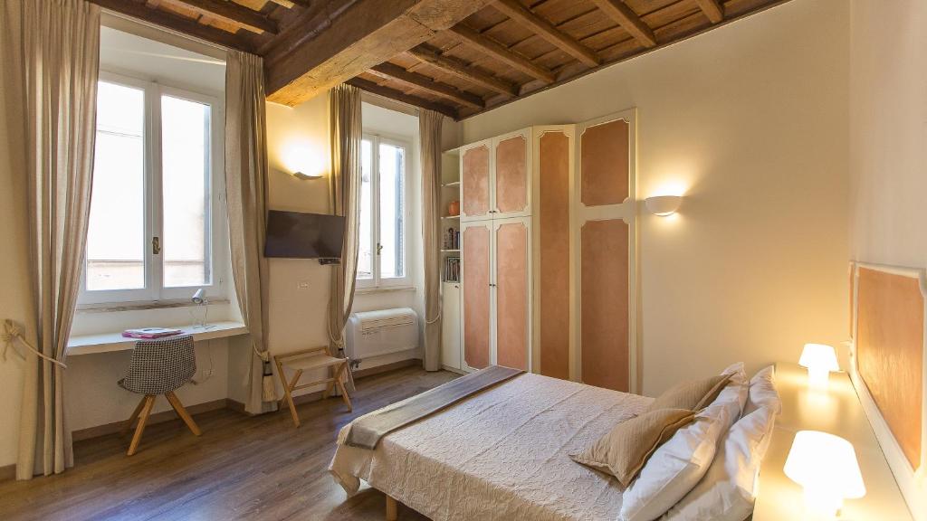 um quarto com uma cama, uma secretária e uma janela em Leutari Suite em Roma
