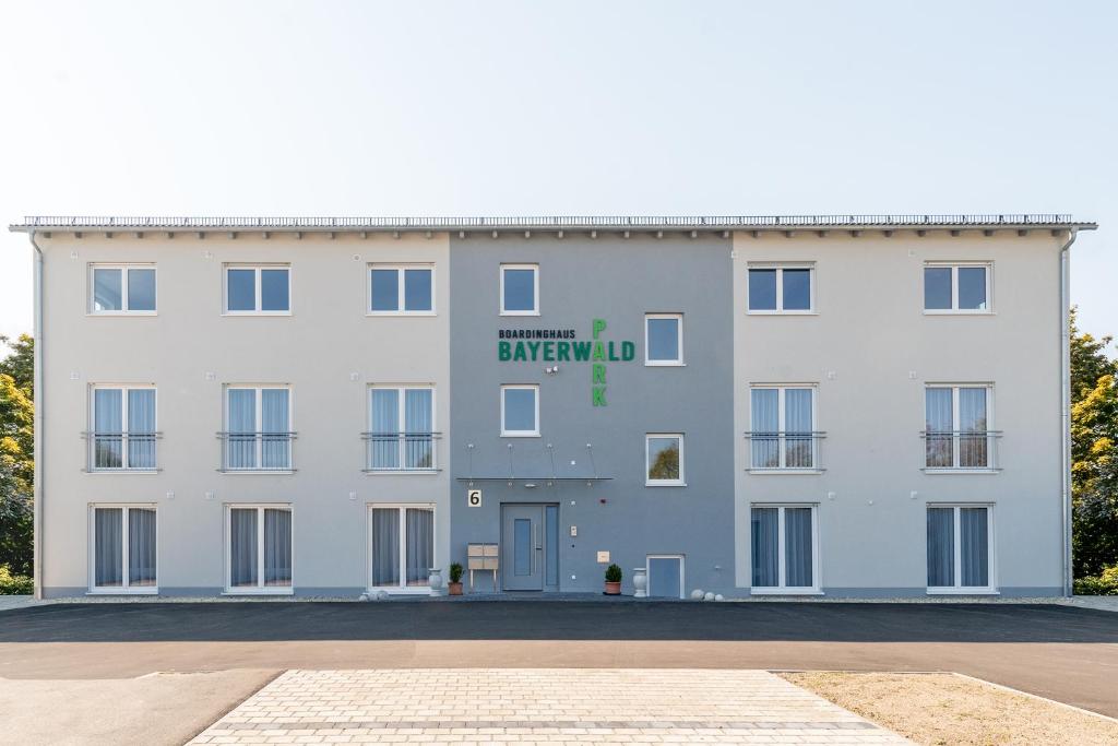 duży biały budynek z zielonym znakiem w obiekcie Boardinghaus Bayerwaldpark w mieście Landshut