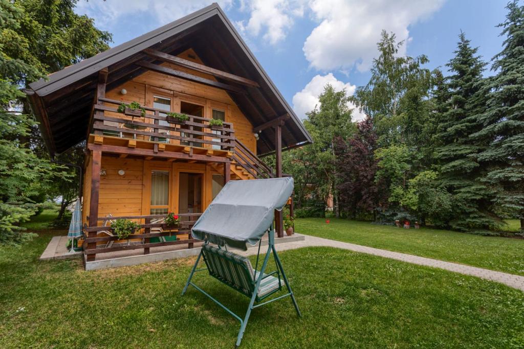 a rake in front of a log house at Brvnara i Apart Zlatiborski Mir in Zlatibor