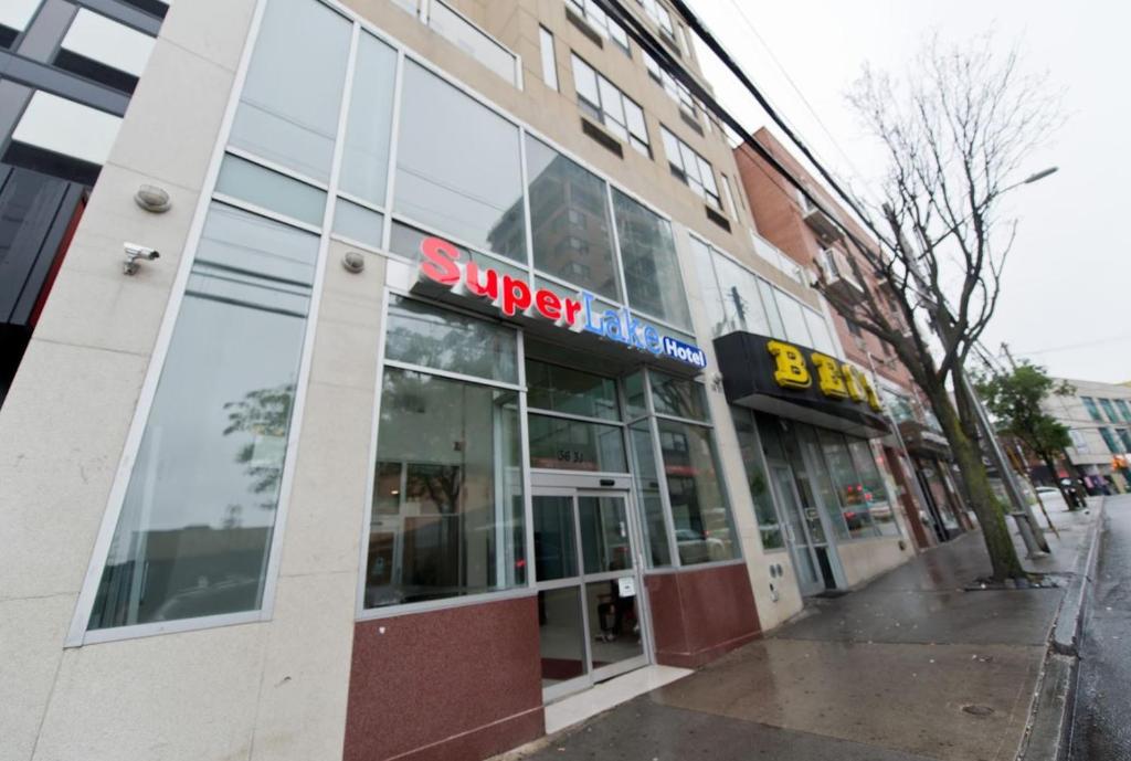 a building with a sign on the front of it at Dynasty Hotel and Suites New York LaGuardia Hotel in Queens
