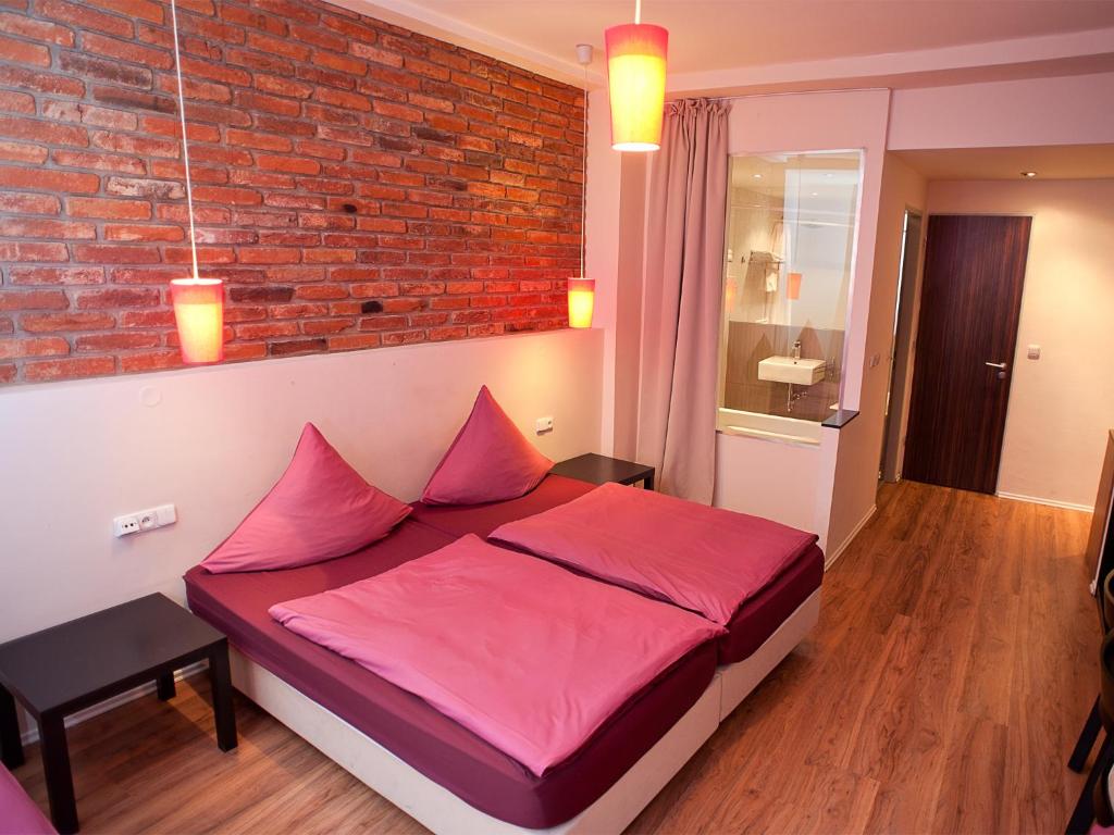 a bed room with a red bedspread and a red wall at Hotel PurPur in Prague