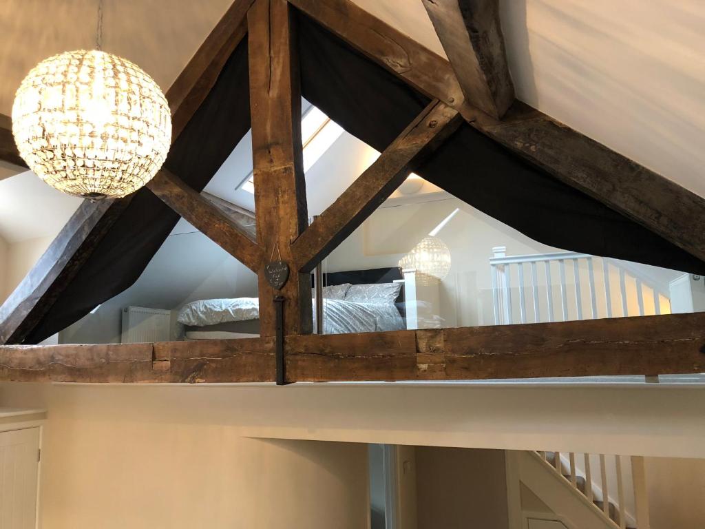 a room with a wooden ceiling with a chandelier at Sunday School House in Shrewsbury