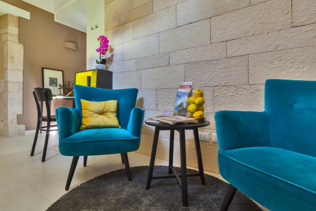sala de estar con 2 sillas azules y mesa en Sciala Ortigia B&B, en Siracusa