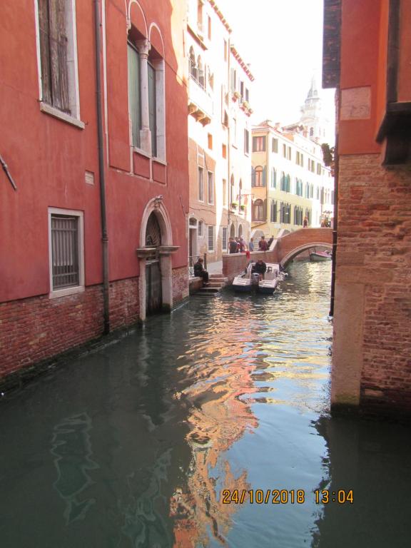 a canal in a city with a boat in the water at Bell Tower House in Venice