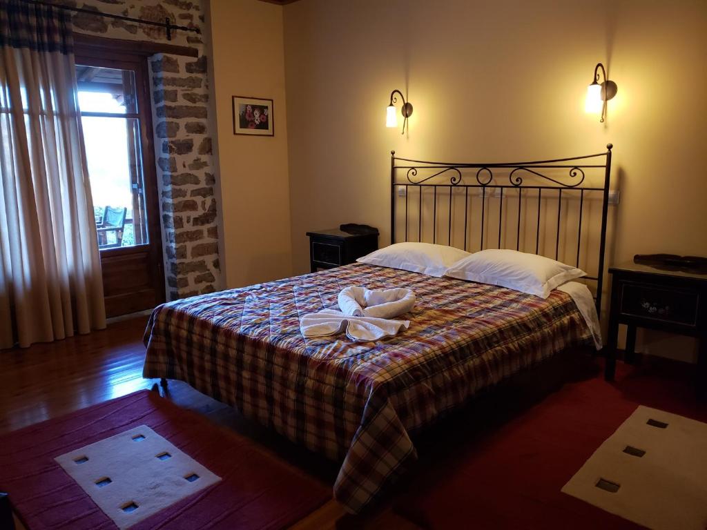 a bedroom with a bed with a bow on it at Dryades Guesthouse in Ano Chora