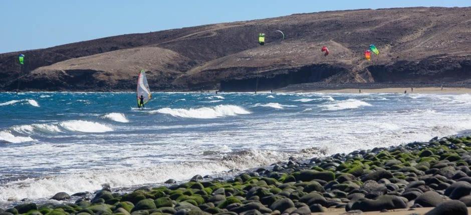 a person on a surfboard in the water at the beach at Vacacional Tegueste 2ºB in Vecindario