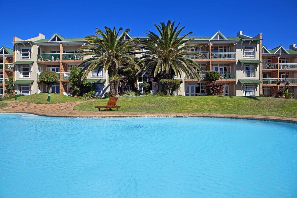 een resort met een groot zwembad en palmbomen bij Brookes Hill suites no 18 in Port Elizabeth