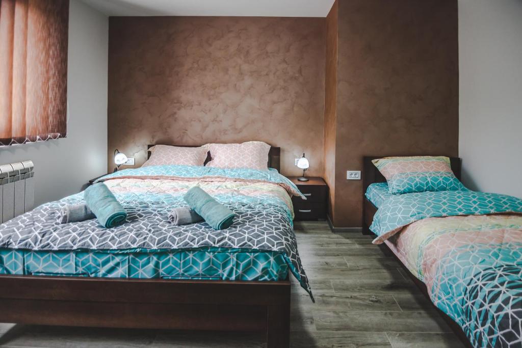 dos camas sentadas una al lado de la otra en un dormitorio en Kristal Apartmani en Arandjelovac