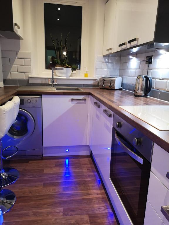 a kitchen with a sink and a dishwasher at Sleep Well Apartment in Glasgow