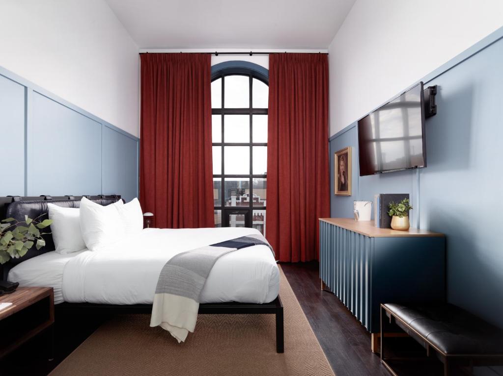 - une chambre avec un grand lit et une fenêtre dans l'établissement The Chicago Hotel Collection Wrigleyville, à Chicago