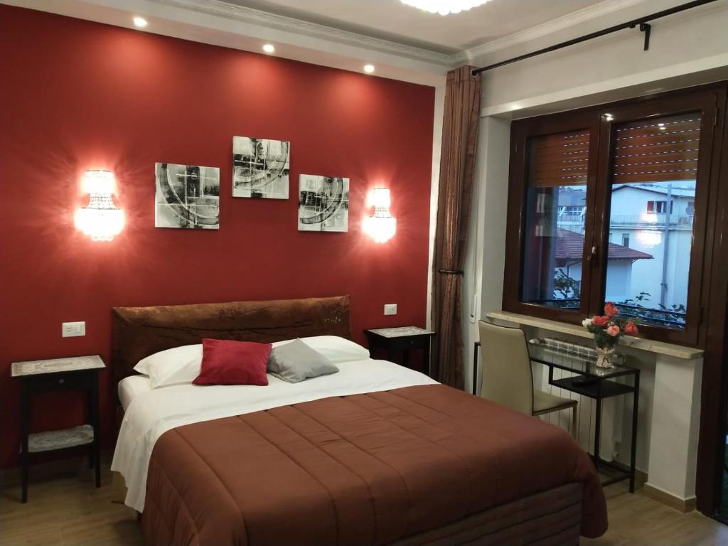 um quarto com uma cama com uma parede vermelha em Seven Miracles Inn em Roma