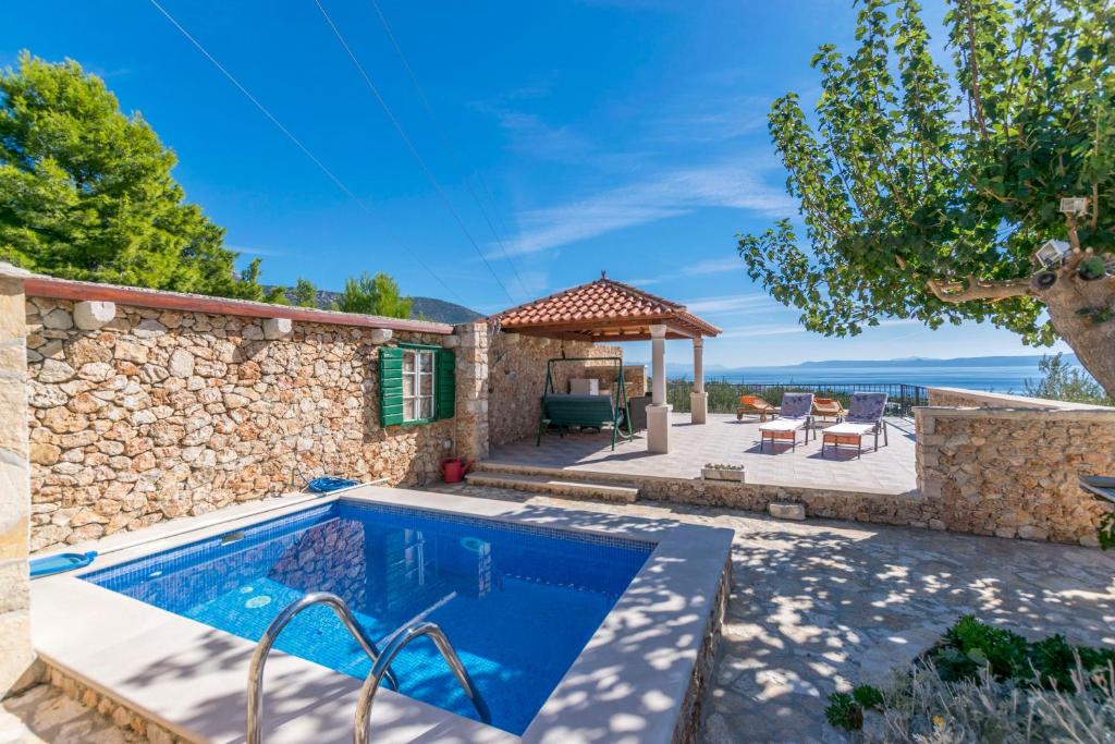 een villa met een zwembad en een patio bij House Petric in Bol