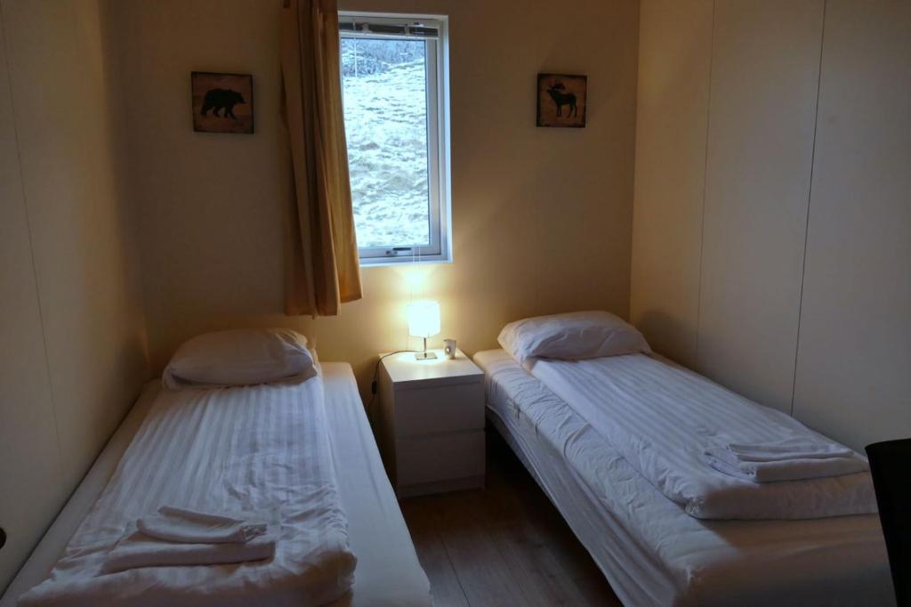two twin beds in a room with a window at Litlabjarg Guesthouse in Hrafnabjorg