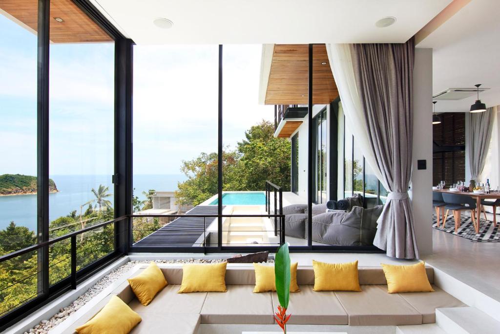 a living room with a couch and large windows at Luxury Sea and Sunset View 4BR 4BA Pool Villa in Mae Haad