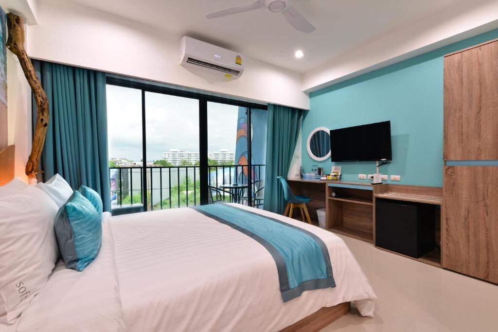 a bedroom with a bed and a desk and a tv at T2 Jomtien Pattaya in Jomtien Beach