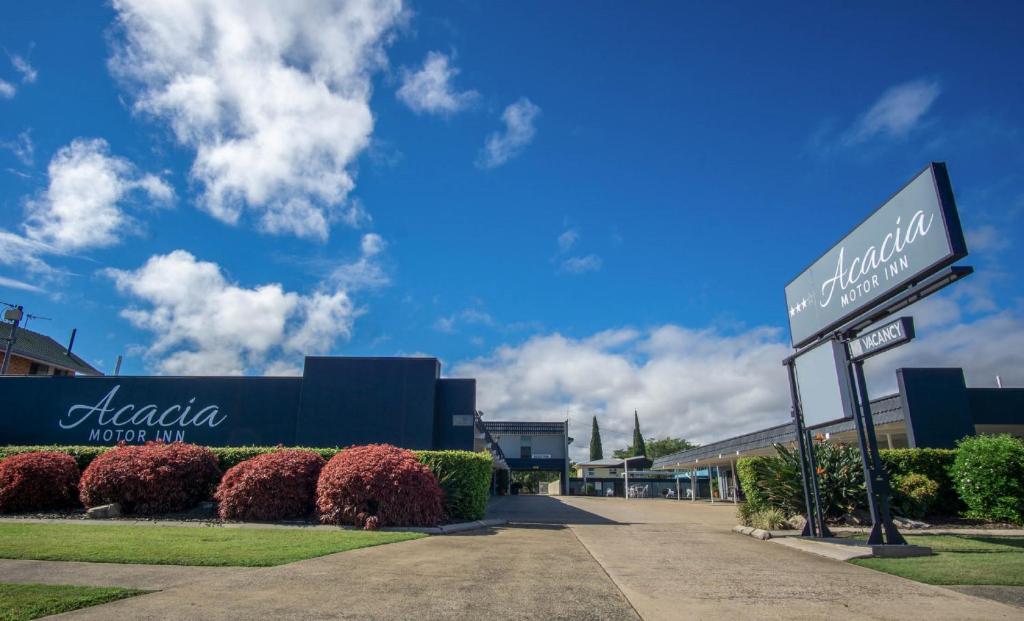 un letrero de la calle frente a un edificio en Acacia Motor Inn en Bundaberg