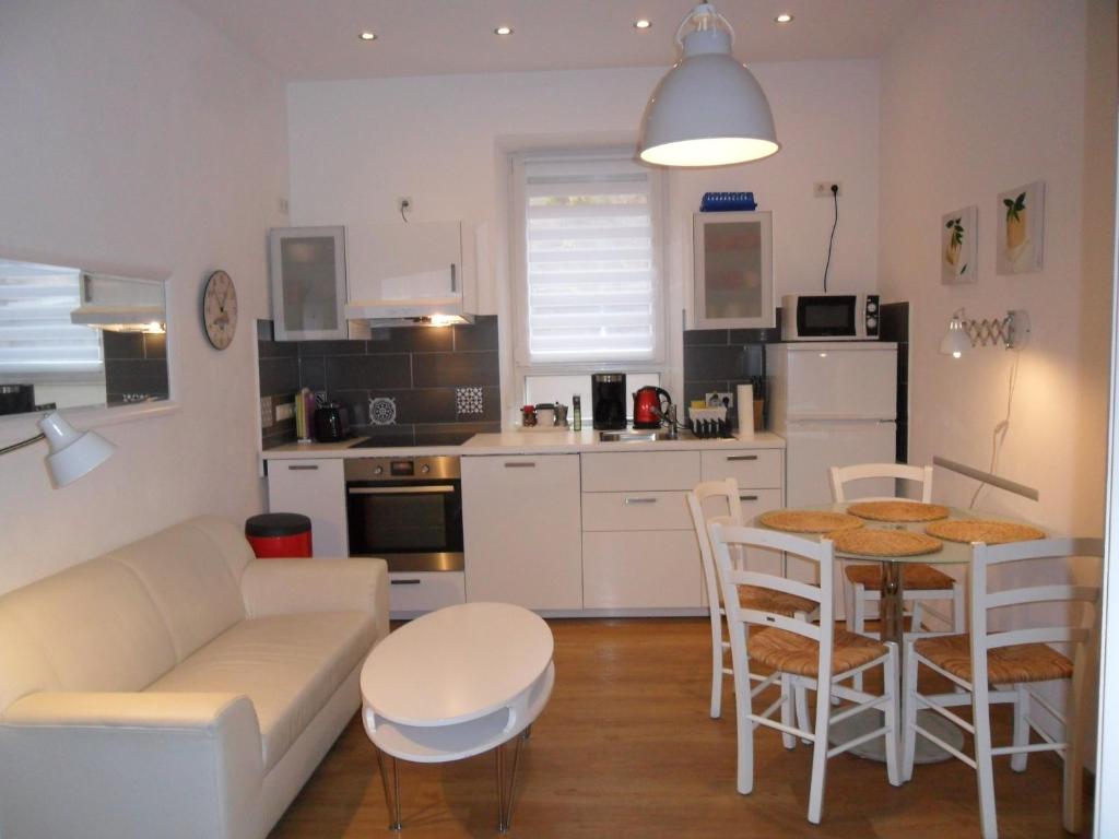 una cucina e un soggiorno con tavolo e divano di City Apartment a Norimberga