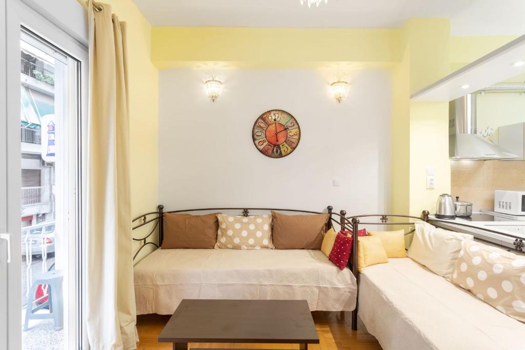 salon z kanapą i zegarem na ścianie w obiekcie Athens Home 2 w Atenach
