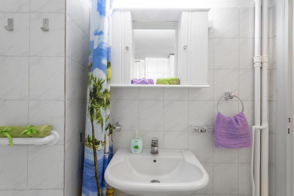 biała łazienka z umywalką i lustrem w obiekcie Athens Home 2 w Atenach