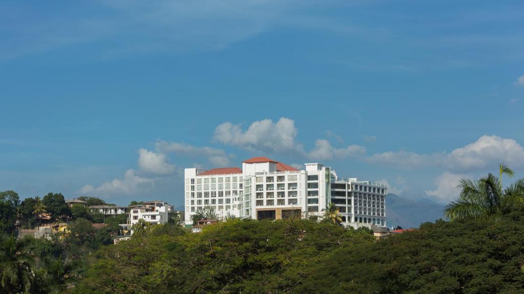 un gran edificio blanco en la cima de una colina en The Grand Kandyan, en Kandy