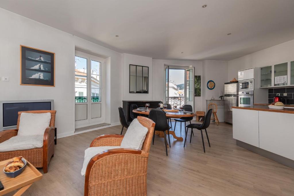 Il comprend une cuisine et un salon avec une table et des chaises. dans l'établissement Le Sky - 3-bedroom apartment, à Nice