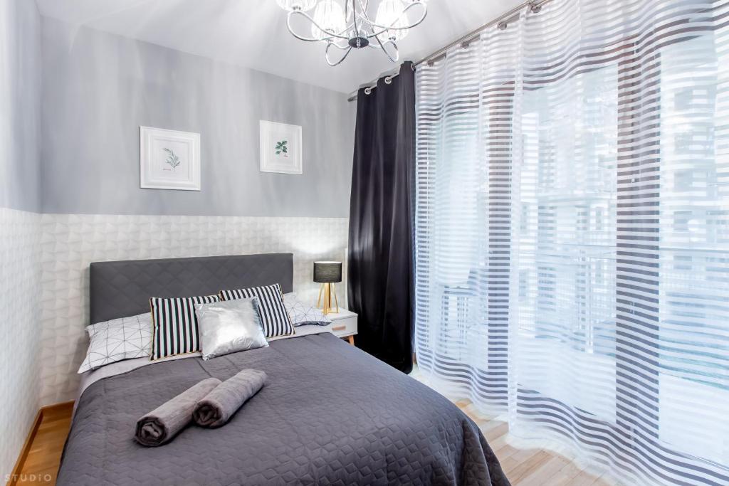 ワルシャワにあるClickTheFlat Sienna Center Apart Roomsのベッドルーム1室(ベッド1台、大きな窓付)