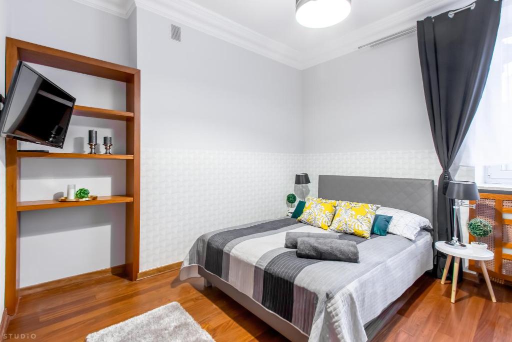 um quarto com uma cama e uma televisão em *ClickTheFlat* Wilcza 33 Street Apart Rooms in the City Center em Varsóvia