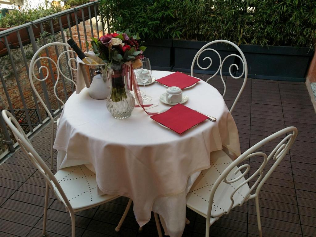 a white table with chairs and a vase of flowers at Hotel Ca' Nobile Corner in Venice