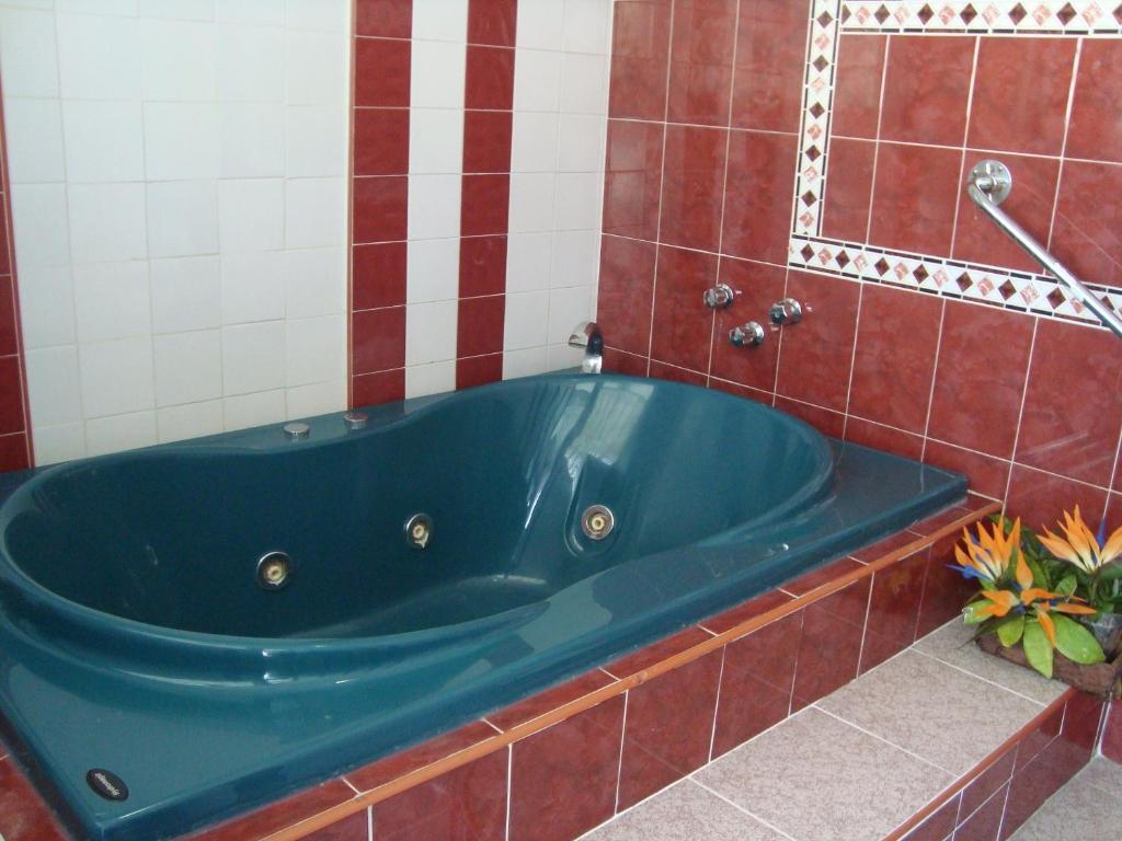 a blue tub in a red tiled bathroom at Suites Angelopolis in Acapulco