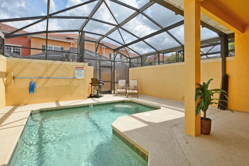 een zwembad in een gebouw met een glazen dak bij Paradise Palms-4 Bed Townhome w/Spashpool-3015PP in Kissimmee