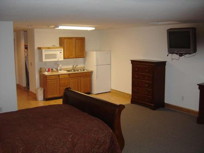 a room with a kitchen with a refrigerator and a sink at Stevens Pass Motel in Gold Bar