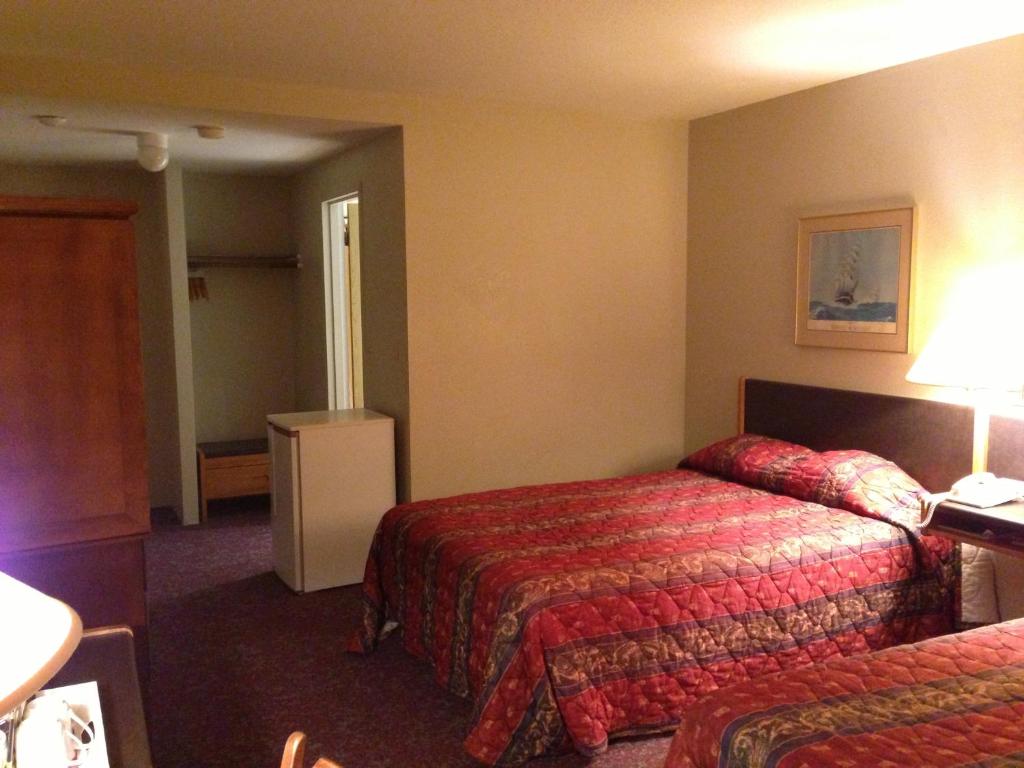 a hotel room with two beds and a lamp at Moby Dick Inn in Prince Rupert