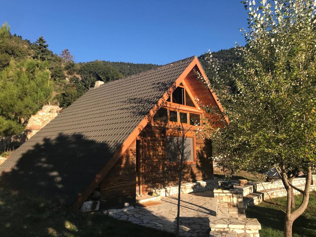 uma cabana de madeira com um telhado de gambrel em Chalet in the Forest em Kalavrita