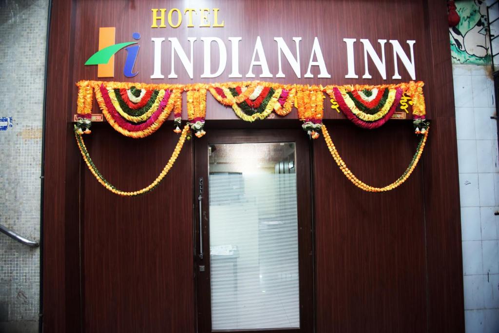 Een deur naar een hotel Indiana Inn met een bord erop. bij Hotel Indiana Inn in Navi Mumbai